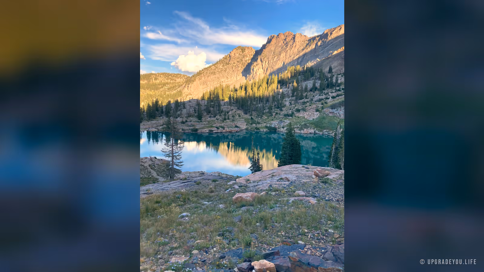 A still, clear alpine lake mirroring the mountains above it