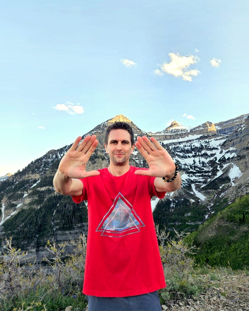 Jess con entrambi i palmi in avanti in una postura Qigong, il Monte Timpanogos innevato alle sue spalle.